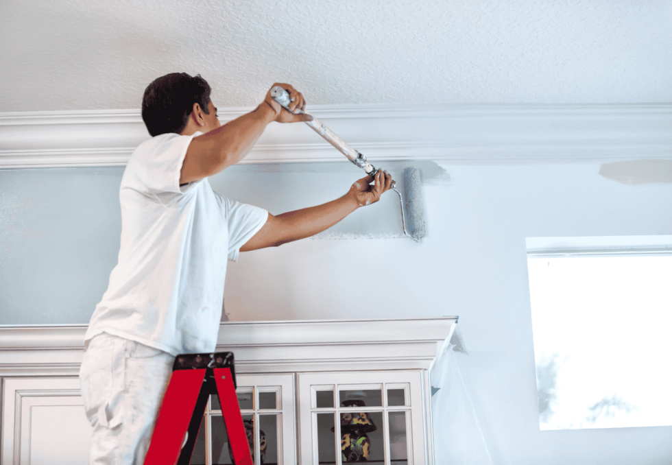 Painter applying interior paint to a villa wall