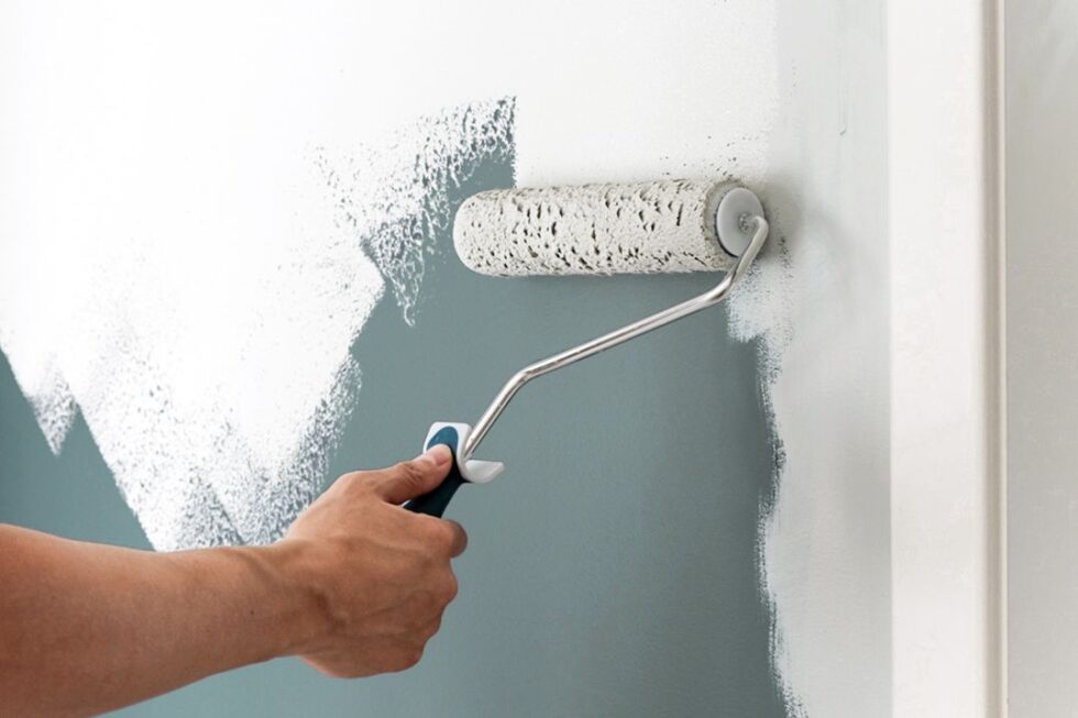Roller applying paint to an apartment wall